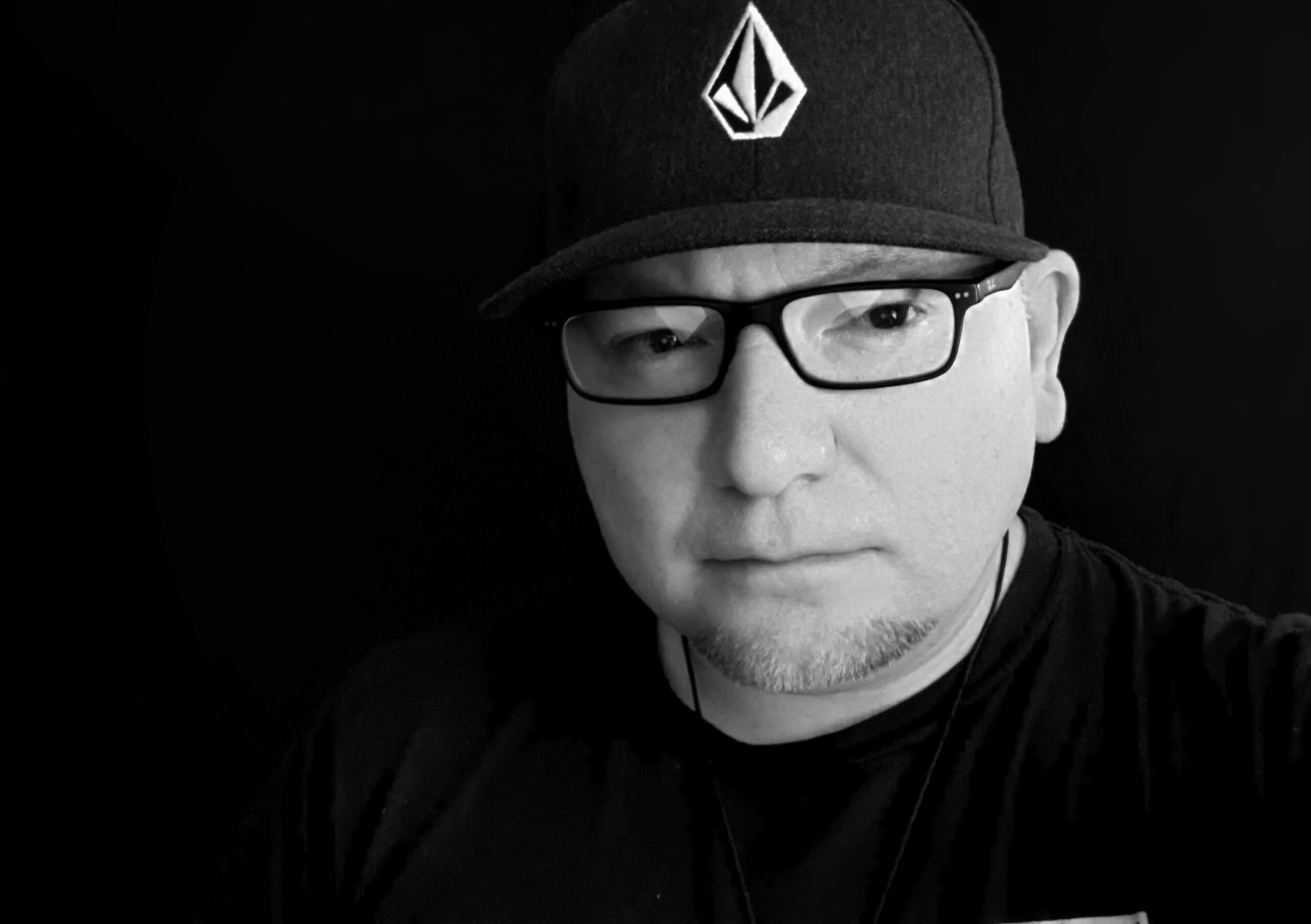 black and white photo of man with glasses and hat on
