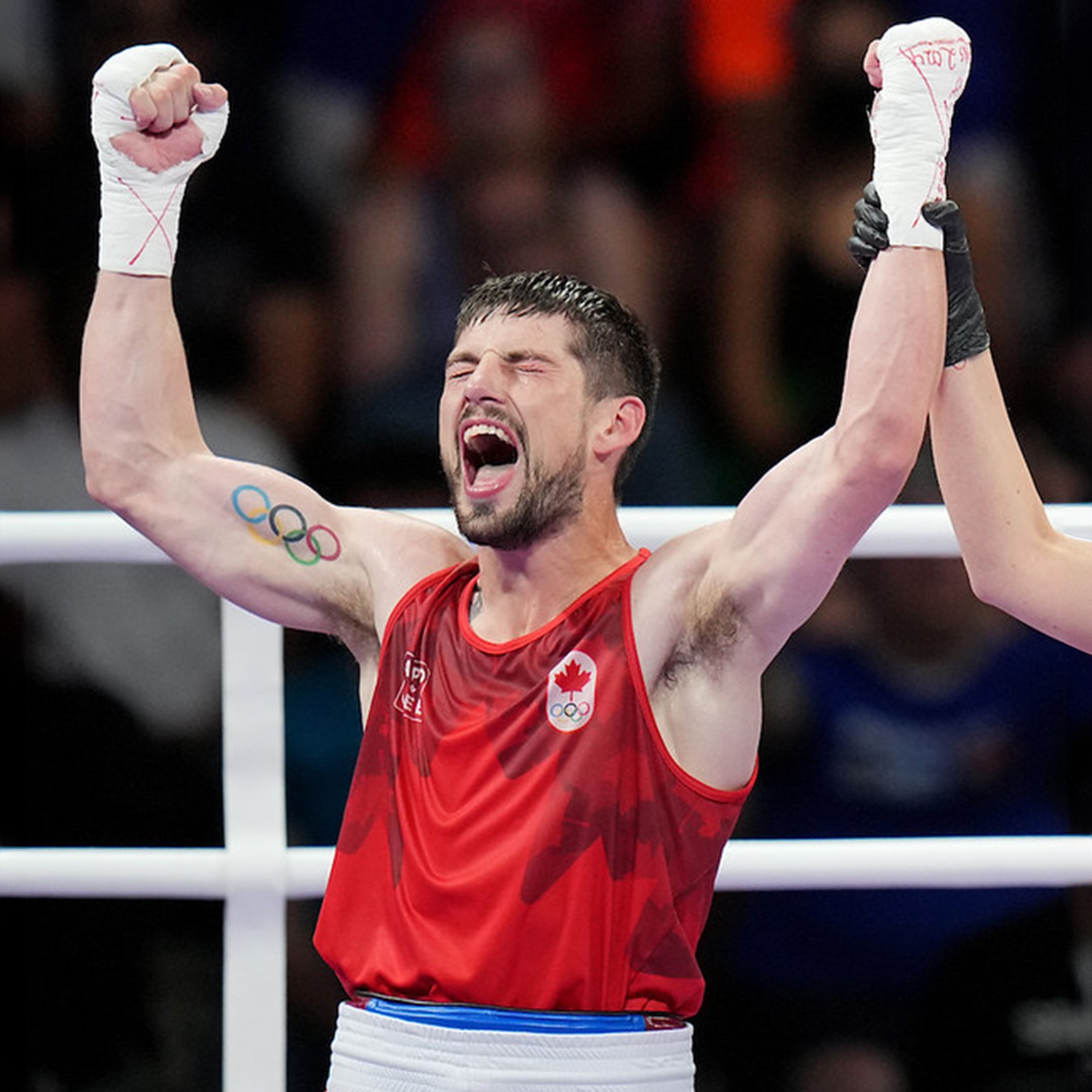 Boxer Wyatt Sanford holds his fists in the air in celebration after winning a match