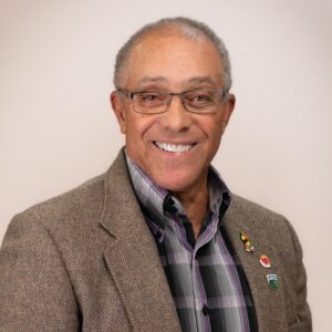 Councillor Norval Mitchell, a smiling man with brown skin, grey hair, hazel eyes, and glasses